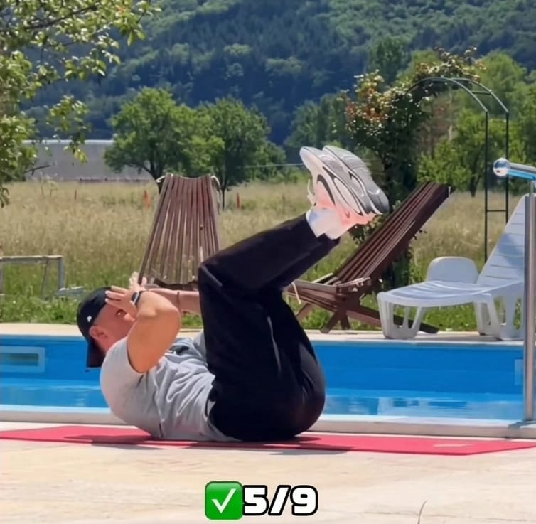 The Sedentary Desk Worker’s Survival Guide: 9 Home Rehab Exercises to Eliminate Lower Back Pain, Anterior Pelvic Tilt, and "Tech Neck" 10 A fitness instructor performing a controlled abdominal crunch on a red mat to fix lower back pain from sitting