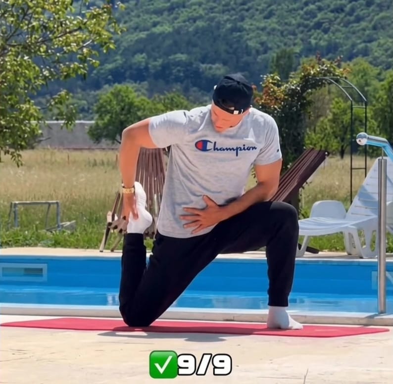 The Sedentary Desk Worker’s Survival Guide: 9 Home Rehab Exercises to Eliminate Lower Back Pain, Anterior Pelvic Tilt, and "Tech Neck" 14 A fitness trainer demonstrating a half-kneeling hip flexor stretch on a red yoga mat to fix lower back pain from sitting
