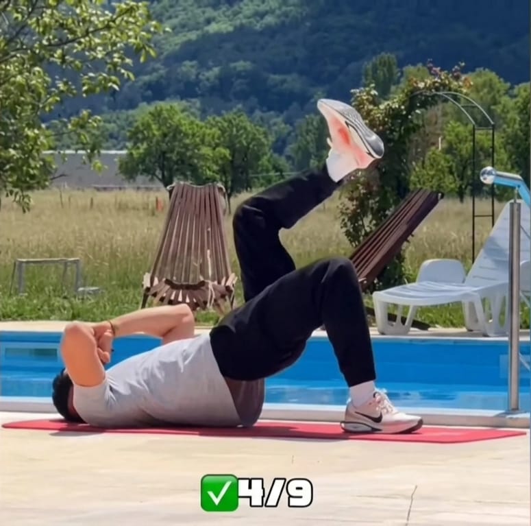 The Sedentary Desk Worker’s Survival Guide: 9 Home Rehab Exercises to Eliminate Lower Back Pain, Anterior Pelvic Tilt, and "Tech Neck" 9 A trainer demonstrating a single-leg glute bridge on a red mat to activate weak glutes and target lower back pain from sitting